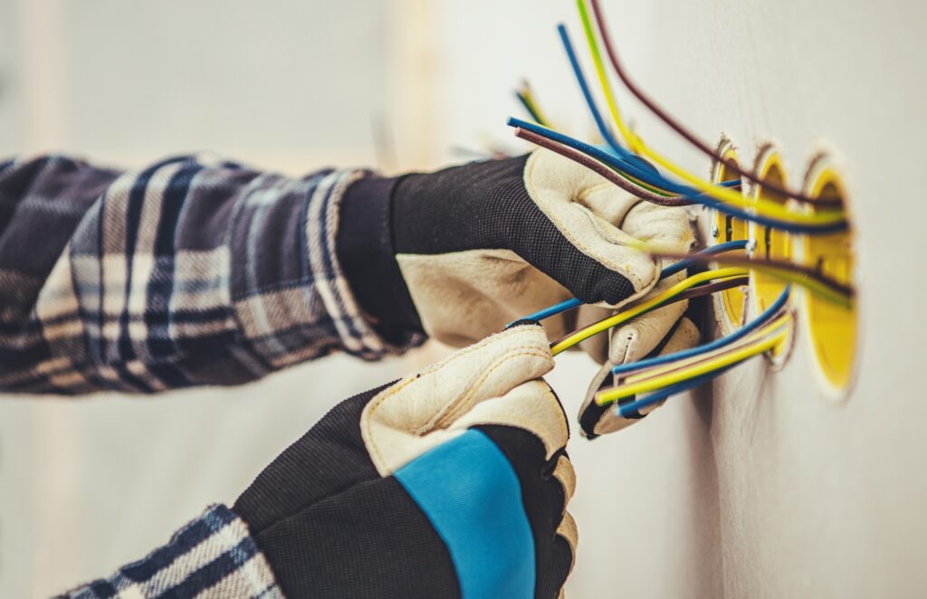 Residential Electric Outlets Installation in a Drywall. Electrician at Work.